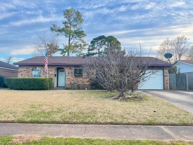 single story home with brick siding, an attached garage, a front yard, fence, and driveway