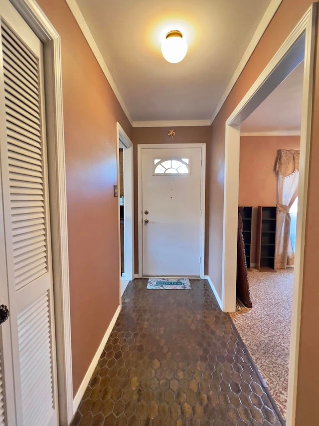 doorway featuring baseboards, ornamental molding, and stone finish flooring