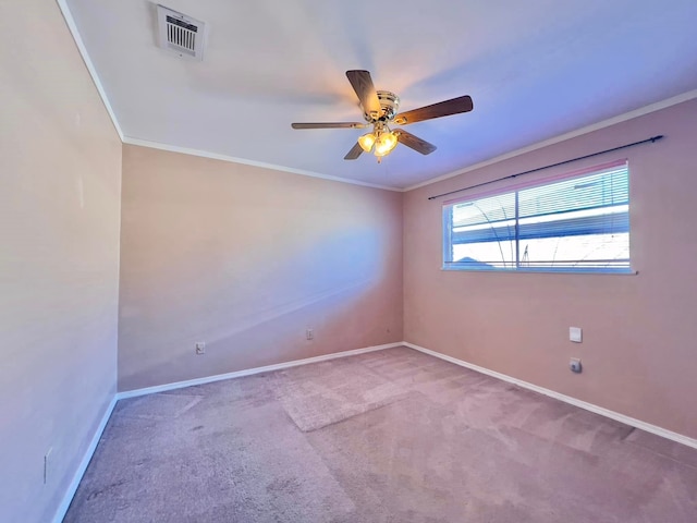 carpeted spare room with a ceiling fan, baseboards, visible vents, and crown molding