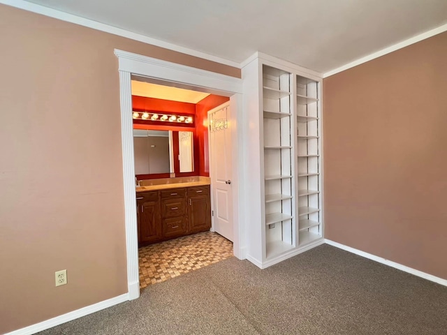 hallway featuring baseboards, carpet flooring, and ornamental molding