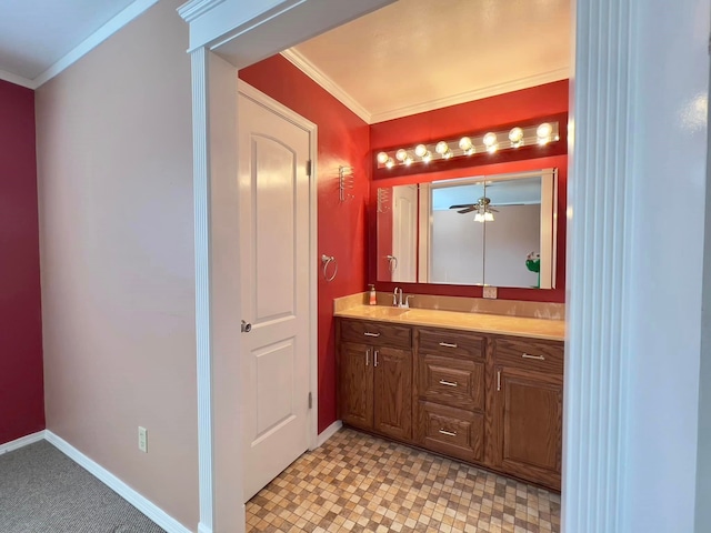 bathroom with baseboards, crown molding, and vanity