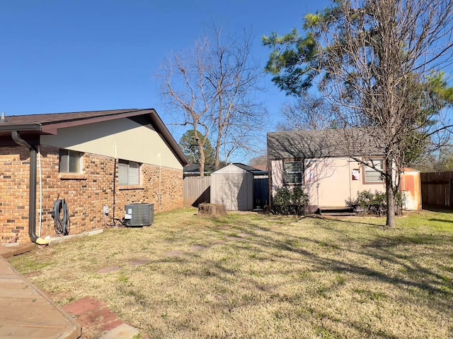 view of yard featuring a storage unit, fence, cooling unit, and an outdoor structure