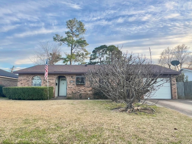 ranch-style house featuring concrete driveway, brick siding, an attached garage, and a front lawn