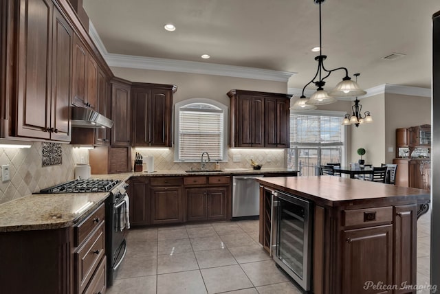 kitchen with black gas range, a sink, beverage cooler, dishwasher, and under cabinet range hood