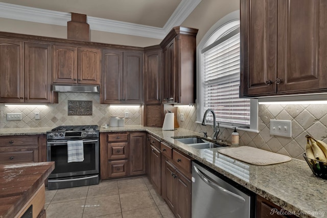 kitchen featuring crown molding, stainless steel appliances, a sink, light stone countertops, and under cabinet range hood