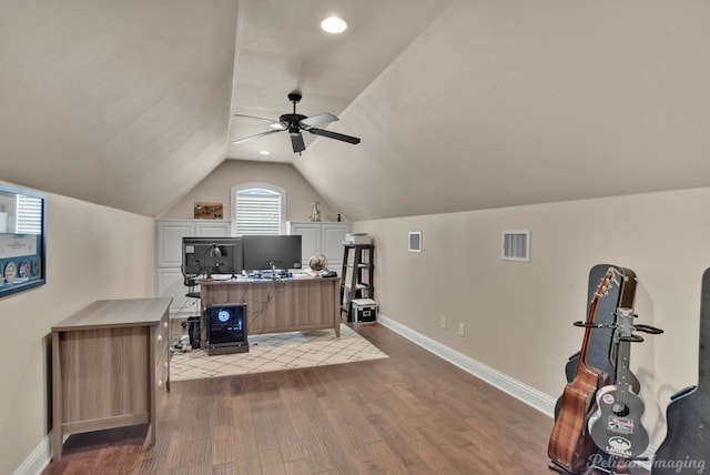 home office featuring visible vents, vaulted ceiling, light wood-style flooring, and baseboards