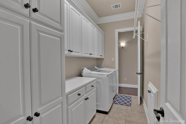 laundry room with cabinet space, light tile patterned floors, visible vents, independent washer and dryer, and crown molding