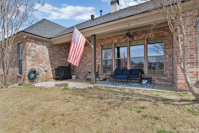 rear view of house with brick siding, a patio, a shingled roof, an outdoor hangout area, and ceiling fan