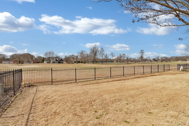 view of yard with fence and a rural view