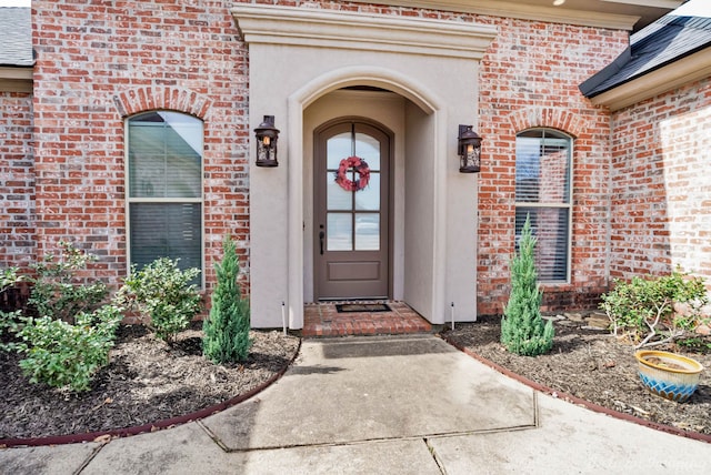 view of exterior entry with brick siding