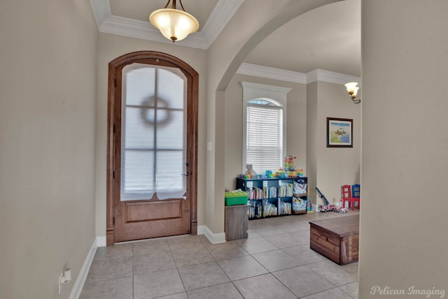 tiled entryway featuring baseboards, ornamental molding, and arched walkways