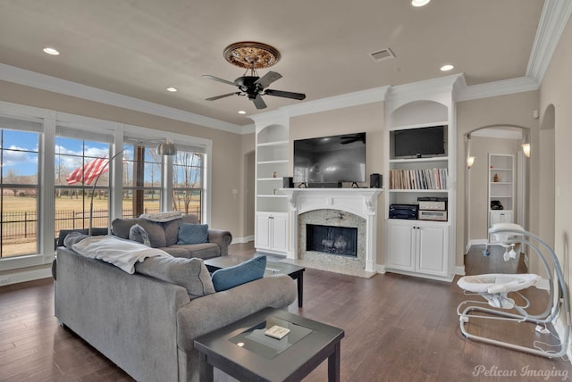 living area featuring dark wood-type flooring, visible vents, crown molding, and a premium fireplace