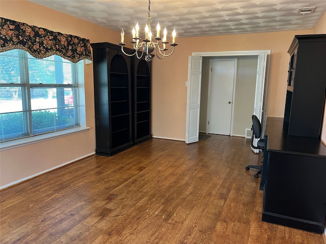 unfurnished office featuring a notable chandelier, visible vents, and dark wood-style flooring