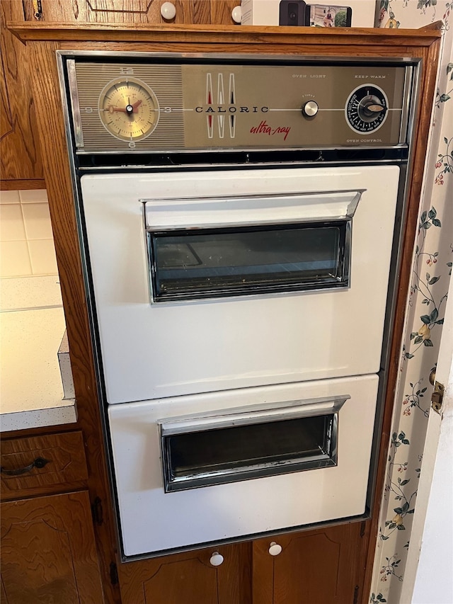 details featuring a warming drawer, double oven, and brown cabinetry