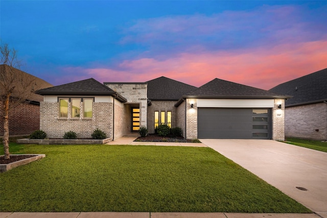 view of front of property with driveway, brick siding, a garage, and a front yard