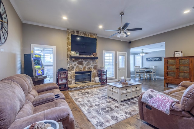 living area featuring ornamental molding, a fireplace, baseboards, and wood finished floors