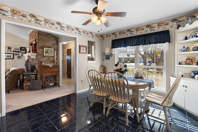 dining room featuring a ceiling fan, granite finish floor, and baseboards