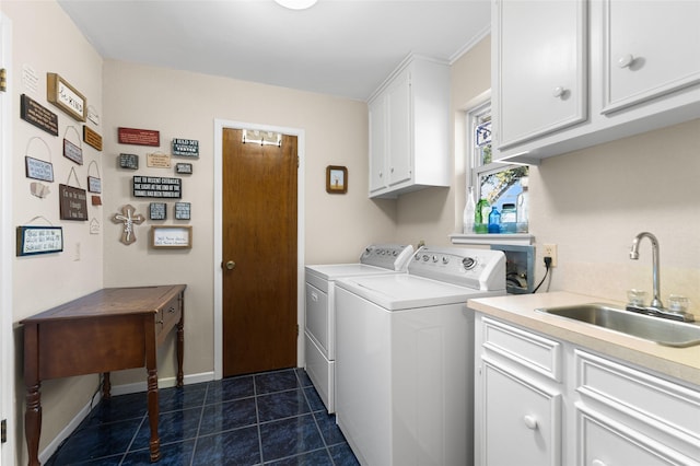 clothes washing area featuring washing machine and clothes dryer, cabinet space, a sink, dark tile patterned flooring, and baseboards