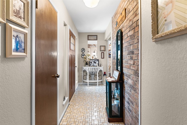 hall with a textured wall and baseboards