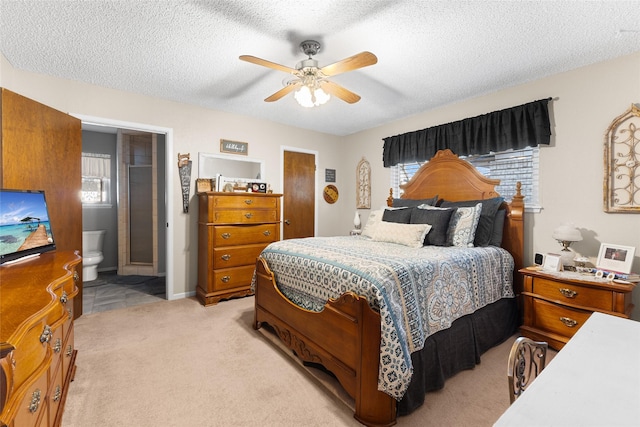 bedroom with a textured ceiling, multiple windows, a ceiling fan, and light colored carpet