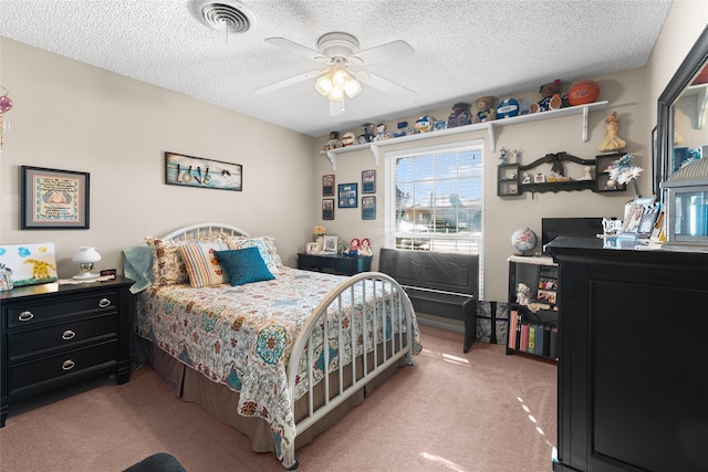 bedroom with a textured ceiling, ceiling fan, visible vents, and light colored carpet