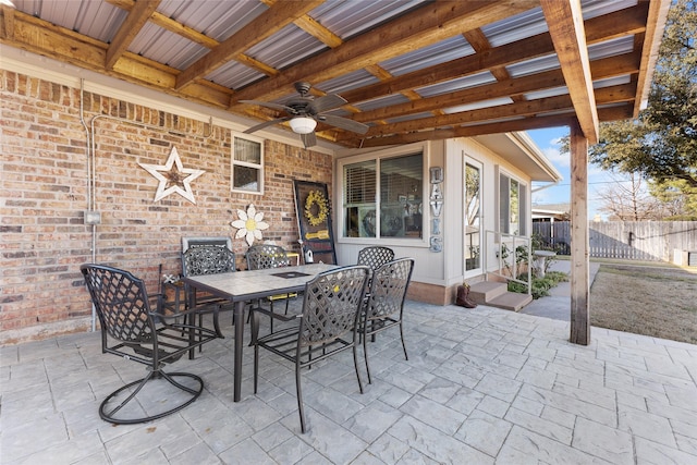 view of patio featuring outdoor dining space, fence, and ceiling fan