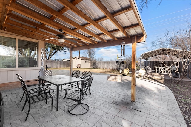 view of patio featuring a storage unit, a ceiling fan, outdoor dining space, a fenced backyard, and an outdoor structure