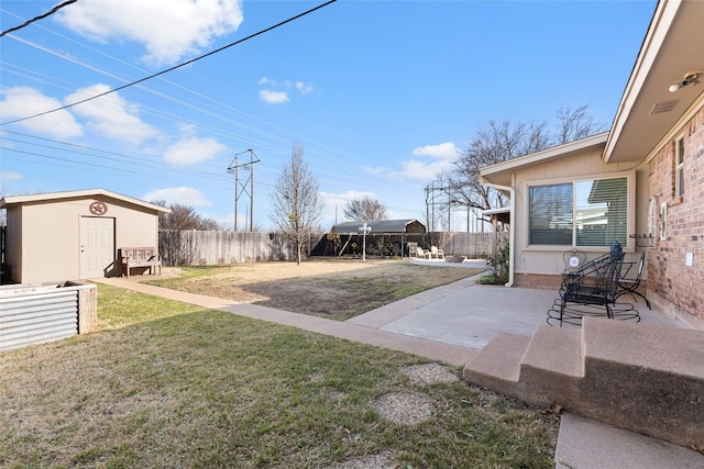 view of yard with an outbuilding, a patio area, and a fenced backyard