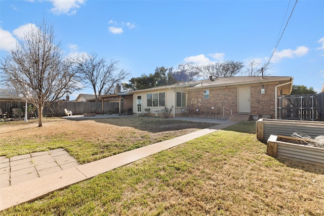 back of property featuring entry steps, brick siding, fence, a lawn, and a patio area