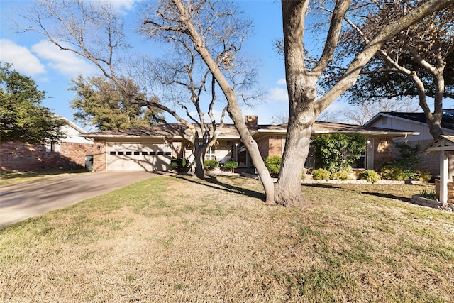 view of front of property featuring driveway, brick siding, a front lawn, and an attached garage