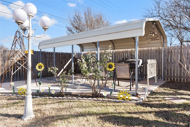 exterior space featuring a detached carport, a patio area, and fence