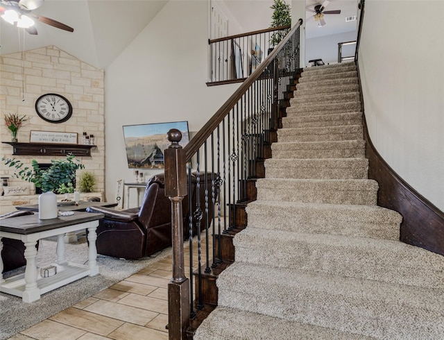stairway featuring high vaulted ceiling and a ceiling fan