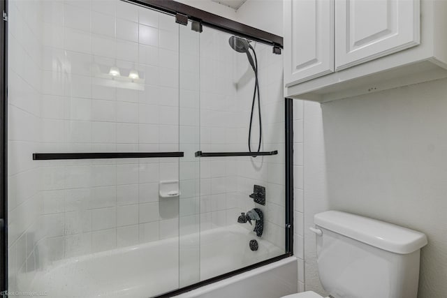 full bathroom with toilet and shower / bath combination with glass door