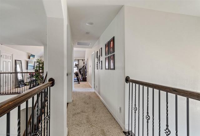 corridor with baseboards, visible vents, carpet, and an upstairs landing