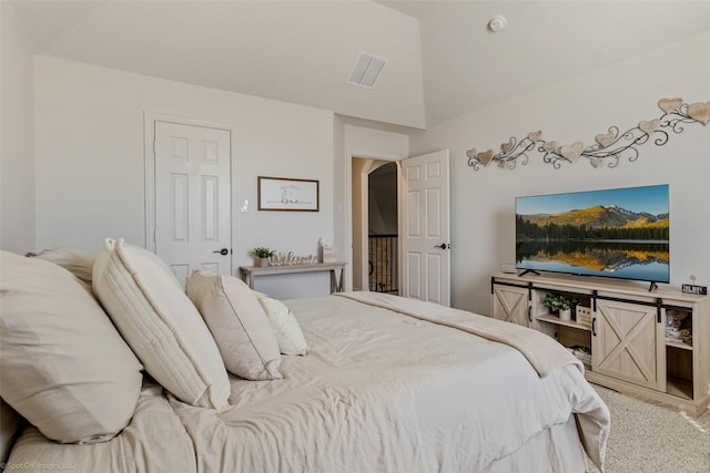 carpeted bedroom featuring lofted ceiling and visible vents