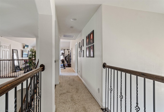 corridor featuring carpet floors, baseboards, visible vents, and an upstairs landing