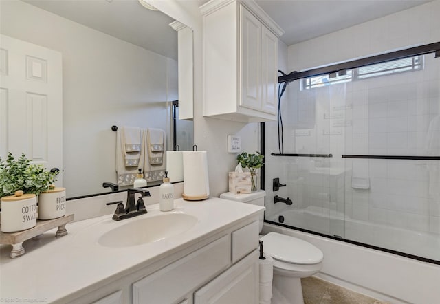 full bathroom featuring combined bath / shower with glass door, vanity, tile patterned floors, and toilet