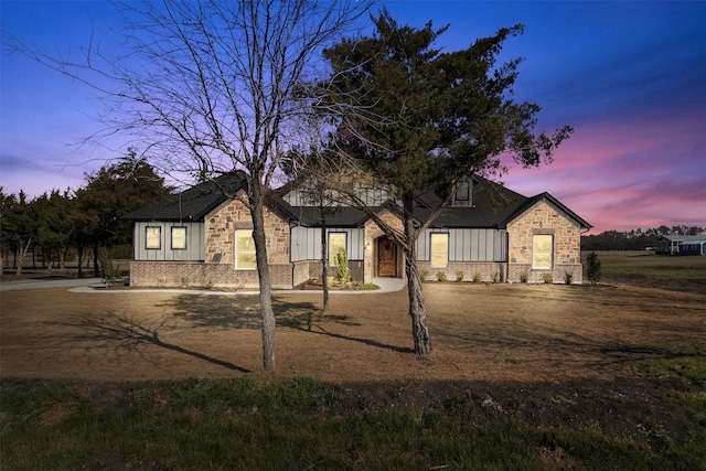 view of front of property featuring stone siding and a chimney