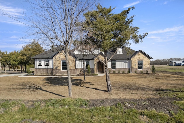 view of front of property with stone siding, a shingled roof, board and batten siding, and brick siding