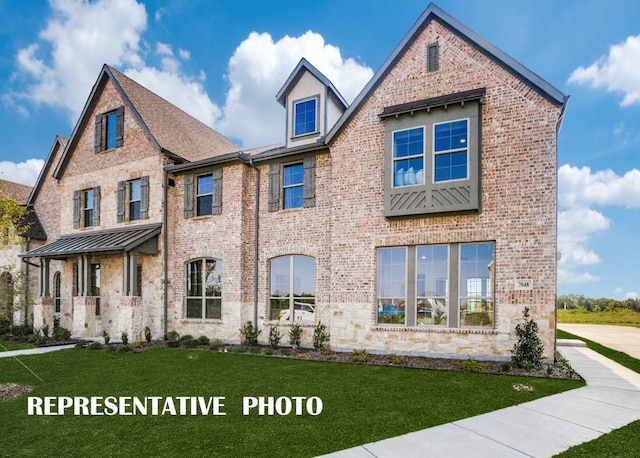 view of front of house with metal roof, brick siding, stone siding, a standing seam roof, and a front yard