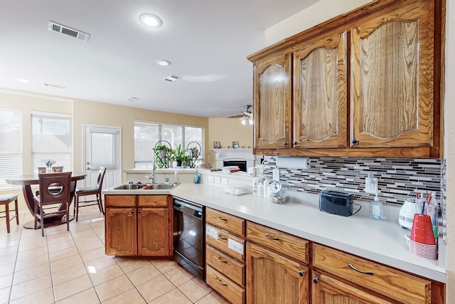 kitchen featuring light tile patterned floors, visible vents, dishwasher, light countertops, and backsplash