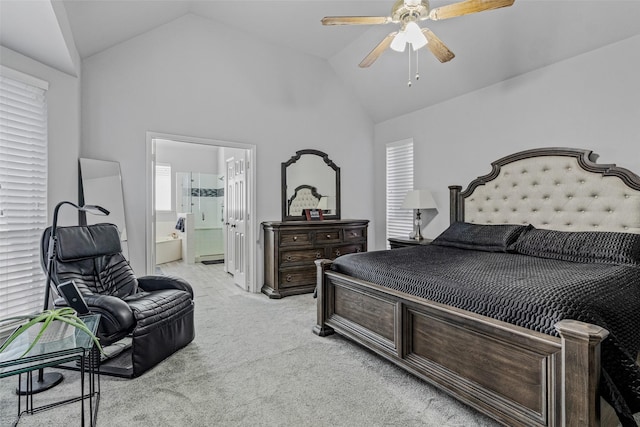 bedroom featuring a ceiling fan, lofted ceiling, light colored carpet, and connected bathroom