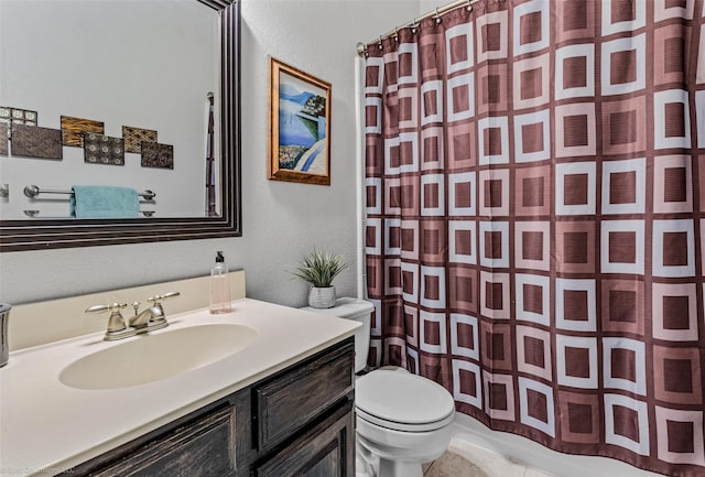 full bathroom with a textured wall, vanity, toilet, and a shower with curtain