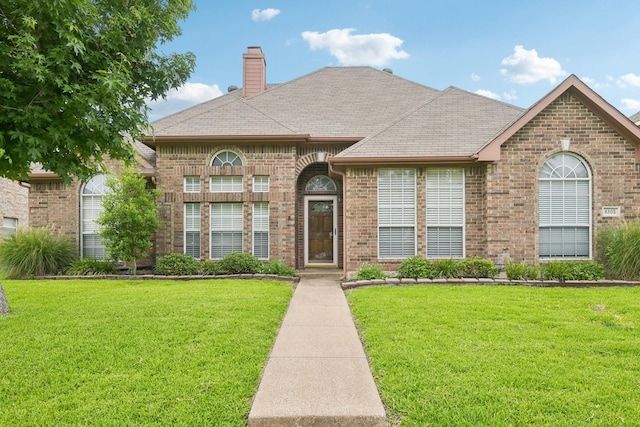 8502 Linda Vista Dr, Rowlett, TX 75088 - french provincial home featuring brick siding, a front yard, a chimney, and a shingled roof