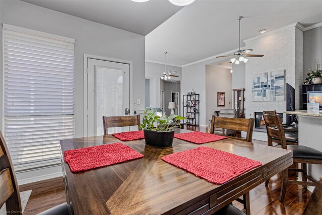 dining space featuring baseboards, wood finished floors, a ceiling fan, and crown molding