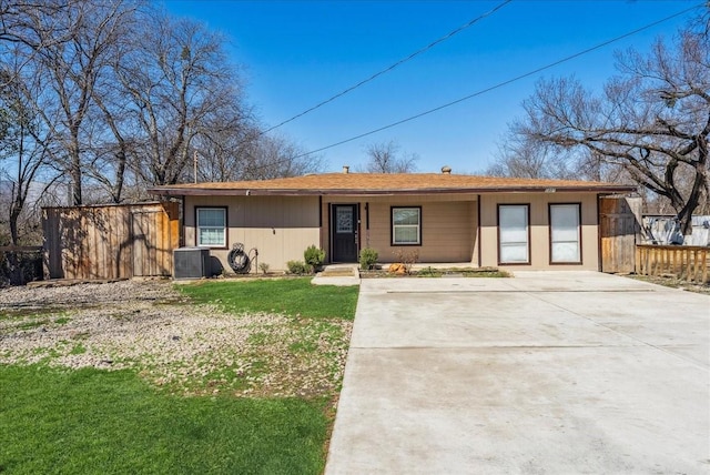 view of front of home with fence, a front lawn, and central air condition unit