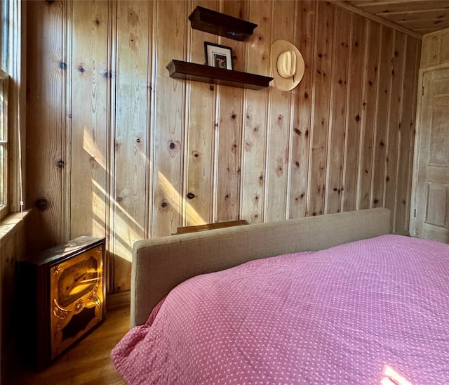 bedroom with wood walls and wood finished floors