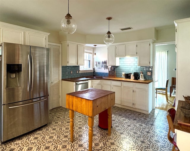 kitchen with white cabinets, visible vents, stainless steel appliances, and a sink