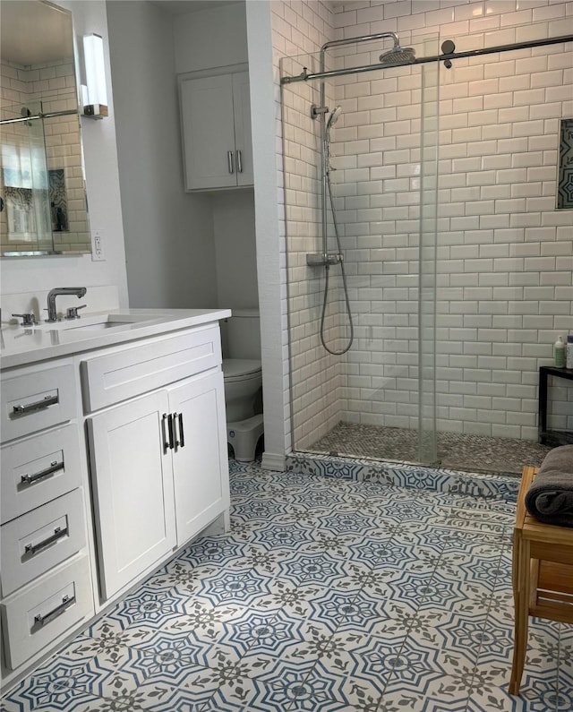 full bathroom with toilet, a stall shower, and vanity