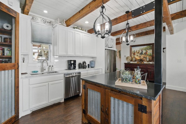 kitchen featuring a sink, an inviting chandelier, stainless steel appliances, dark wood finished floors, and backsplash